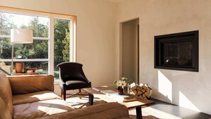 Un salon moderne comprenant un canapé, un fauteuil, une table basse et une cheminée.