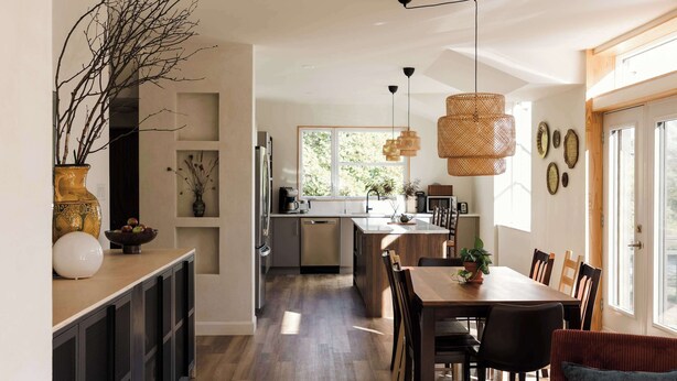 Une cuisine moderne dotée d’un îlot central, de meubles en bois et de luminaires suspendus.