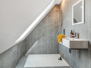A modern bathroom with a shower, a sink, and a mirror.
