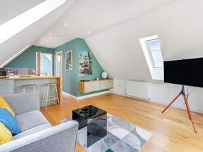 En moderne loftlejlighed med køkken, spiseplads og opholdsstue.