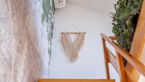 A wooden staircase with a macrame wall hanging. - GuestReady - Autumn Apartment (Bairro Alto)