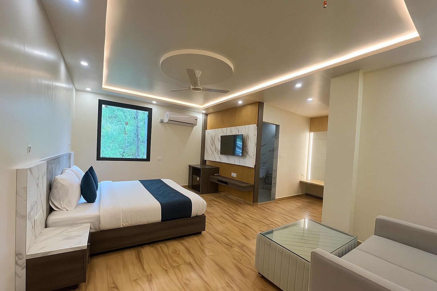 A modern bedroom with a bed, a TV, a ceiling fan, and a large window.
