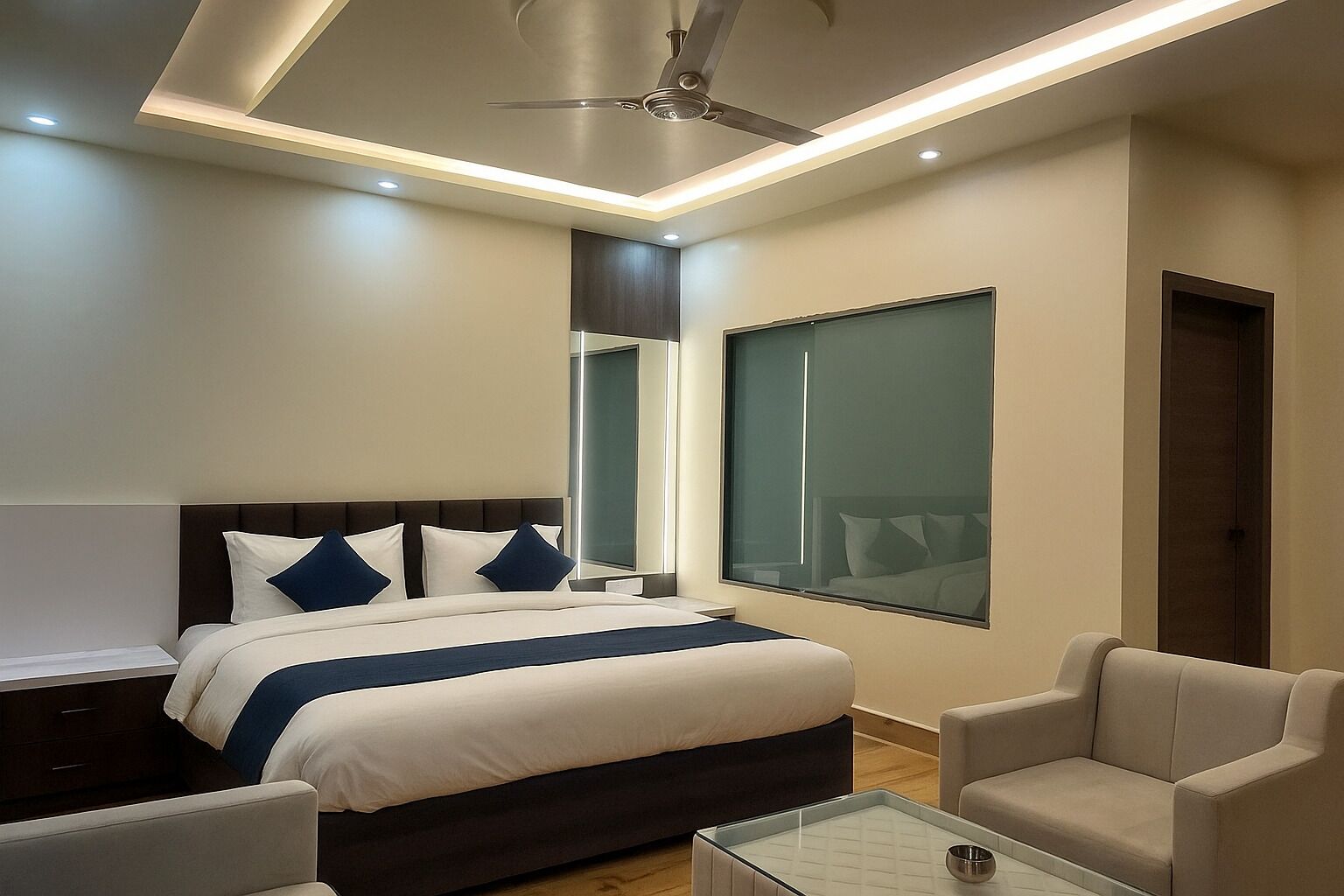 Une chambre d’hôtel moderne dotée d’un grand lit, d’un ventilateur de plafond, d’une table basse en verre et offrant une vue sur la ville grâce à une grande fenêtre.