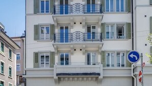 Un edifici de diverses plantes d'estil arquitectònic tradicional, amb balcons i una entrada central amb una porta i finestres.