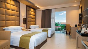 Une chambre d’hôtel avec deux lits, un canapé, un bureau et une télévision.
