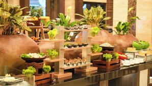 Un buffet proposant une variété de plats et agrémenté de plantes décoratives.