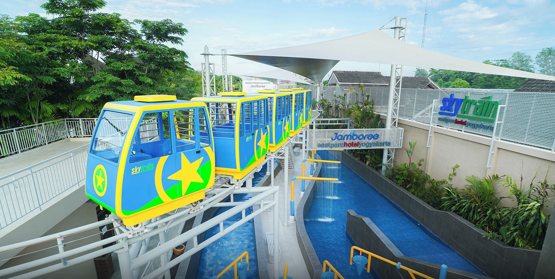 A water ride with a blue and yellow gondola, a pool, and a building with a sign.
