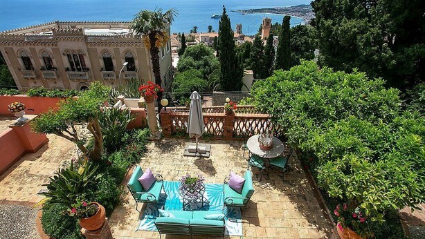 A patio with outdoor furniture, potted plants, and a view of the sea. - Villa Doride Grande: An elegant and welcoming three-story residence which faces the sun and the sea, with Free WI-FI. (Taormina)