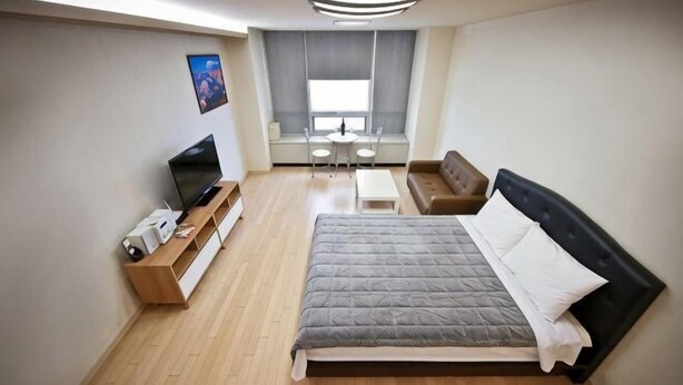A bedroom with a bed, a TV, a desk, and a window. - Incheon Airport Prime Guesthouse (Incheon)