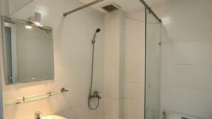 Une salle de bain moderne avec une douche à parois de verre, un lavabo blanc et des toilettes.