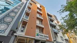 A modern hotel with a prominent vertical wooden panel design, balconies, and a glass facade. - Treebo Liyan Orchid, Hsr Layout (Bengaluru)
