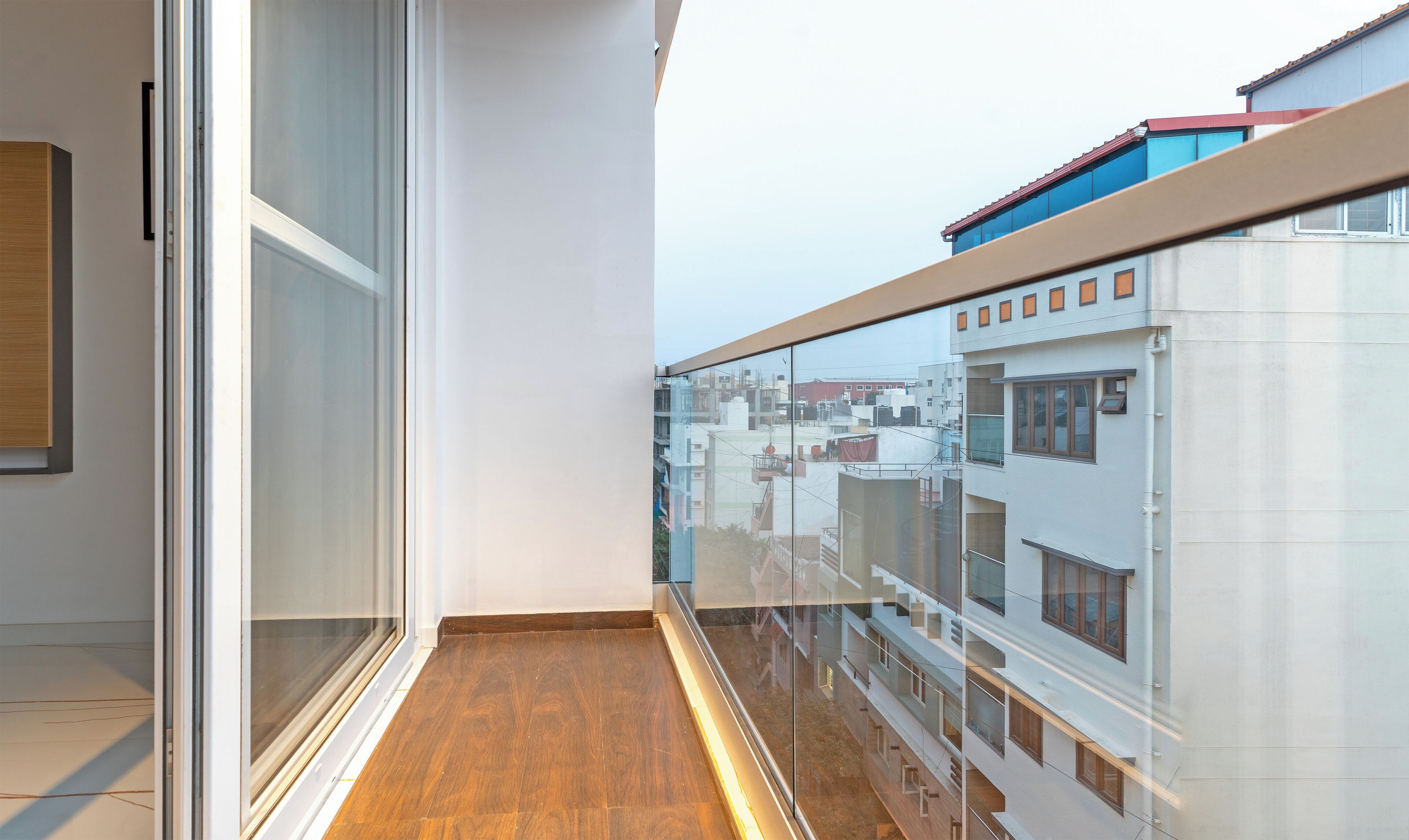 A modern apartment with a balcony overlooking a cityscape.