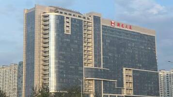 A high-rise building with a prominent red logo on the top.