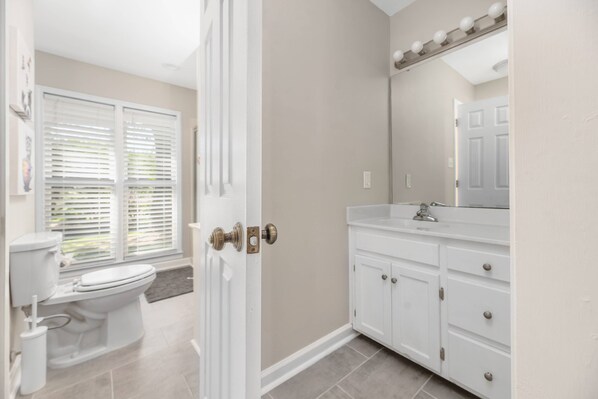 A bathroom with a toilet, sink, and vanity.