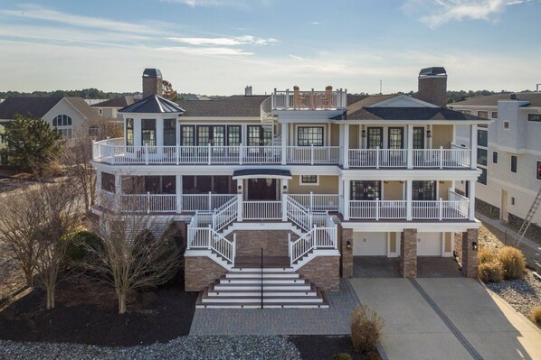 A multi-story residential building with a central staircase, multiple balconies, and a well-maintained front yard. - 121 Breakwater Reach, Cape Shores (Lewes)