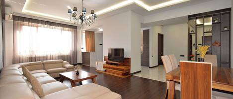 Family Apartment, Balcony, City View | Living area | 50-inch flat-screen TV with cable channels