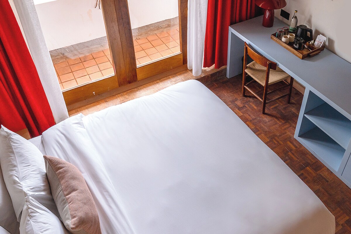 Ein Hotelzimmer mit Bett, Schreibtisch und Stuhl.