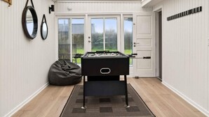 A room with a foosball table, a bean bag, and a large mirror on the wall. - 5 Star Holiday Home in Slagelse (Slagelse)