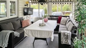 Ein gemütliches Wohnzimmer mit einer Couch, einem Tisch und einem Fernseher.