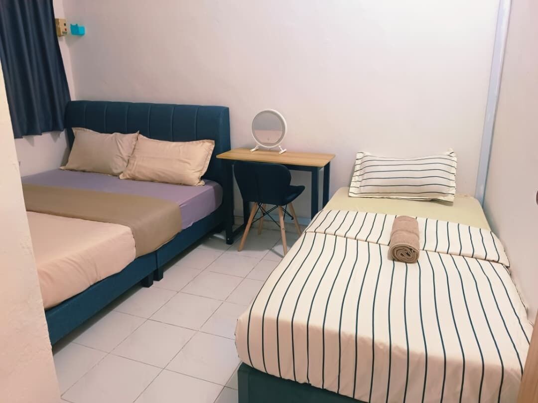 Una habitación con dos camas, un escritorio, una silla y un espejo.