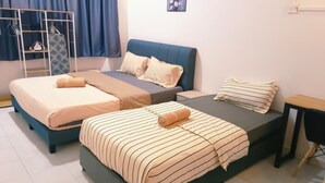 Une chambre avec deux lits, une petite table et une armoire.