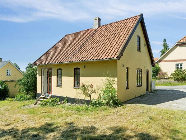 A single-story house with a tiled roof, a front door, and a small porch. - 5 Star Holiday Home in Tranekaer (Tranekaer)