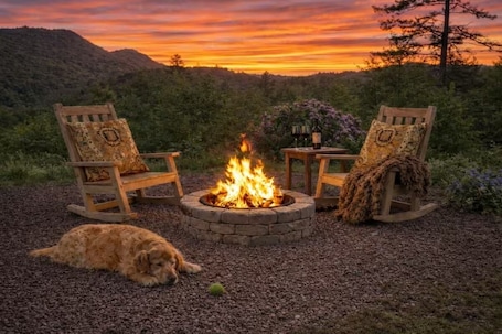A fire pit with two wooden chairs and a dog lying nearby.. Tiny House. Wrong Size.• Cal King+Dog Yard+Boat Parking • 3,543ft Above Ordinary