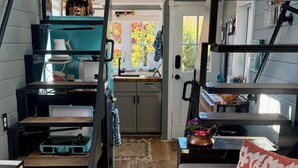 Un espacio habitable compacto y funcional con cocina, comedor y una zona de estar acogedora.
