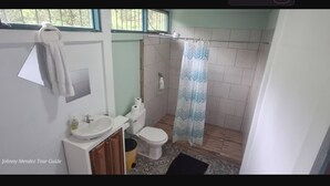 A bathroom with a toilet, sink, and shower curtain.