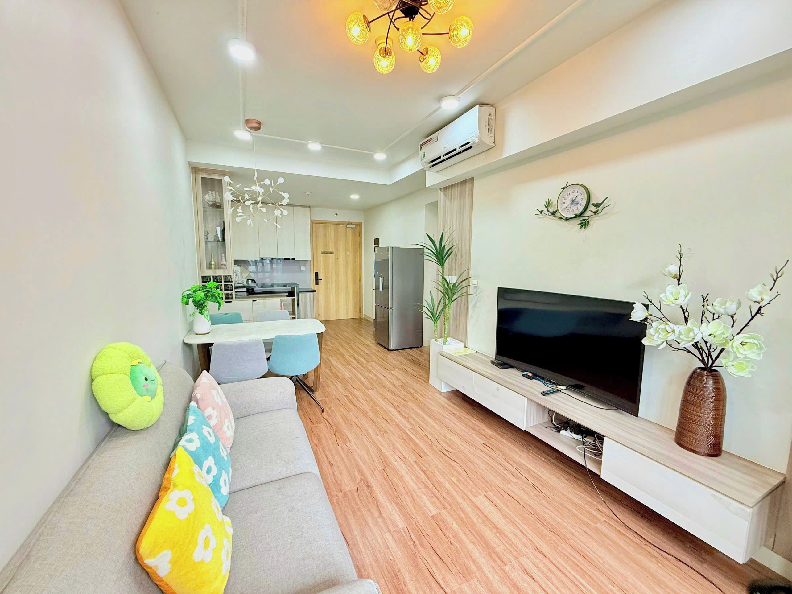 Una sala de estar moderna con un sofá, televisor y plantas decorativas.