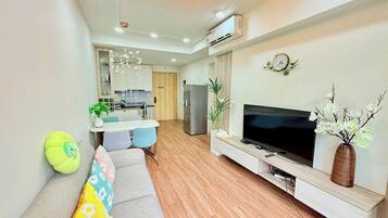 Una sala de estar moderna con un sofá, televisor y plantas decorativas.