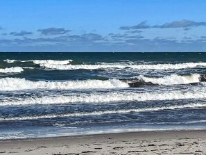 A beach with waves and a clear sky.