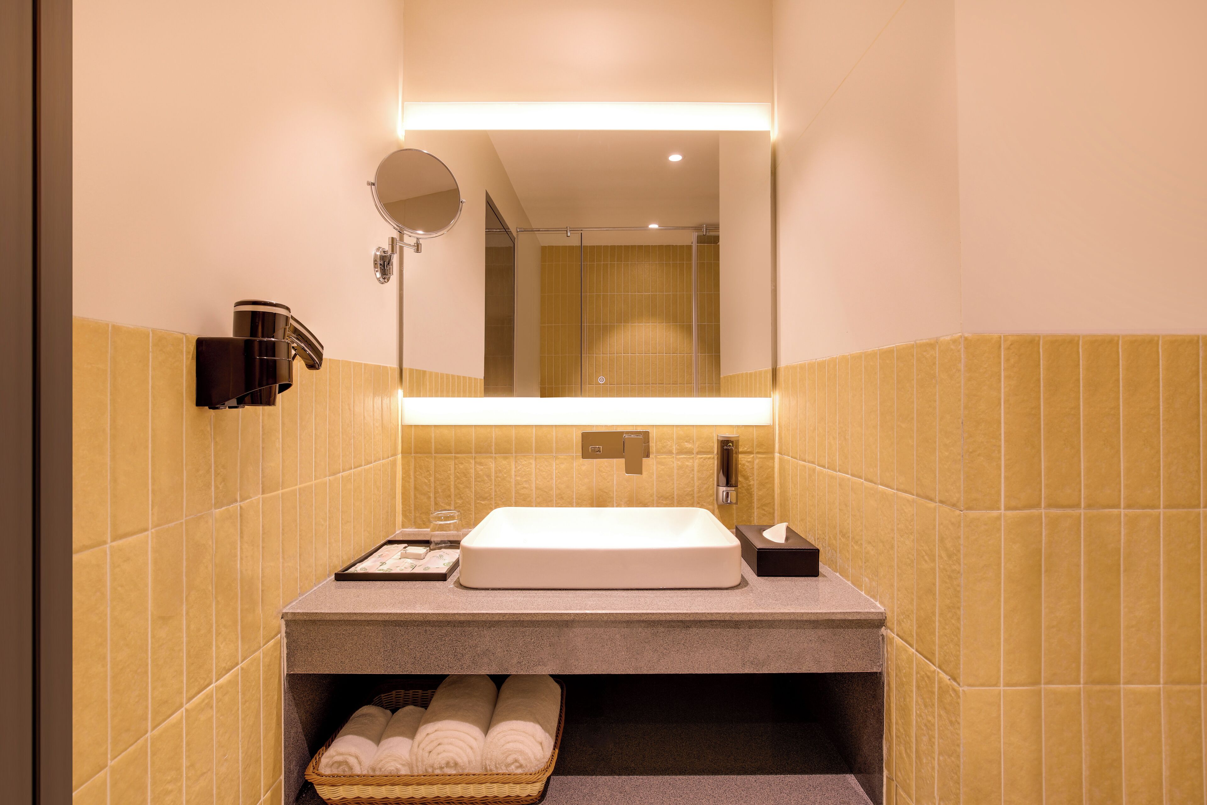 Un baño moderno con un espejo grande, un lavabo y un perchero para toallas.