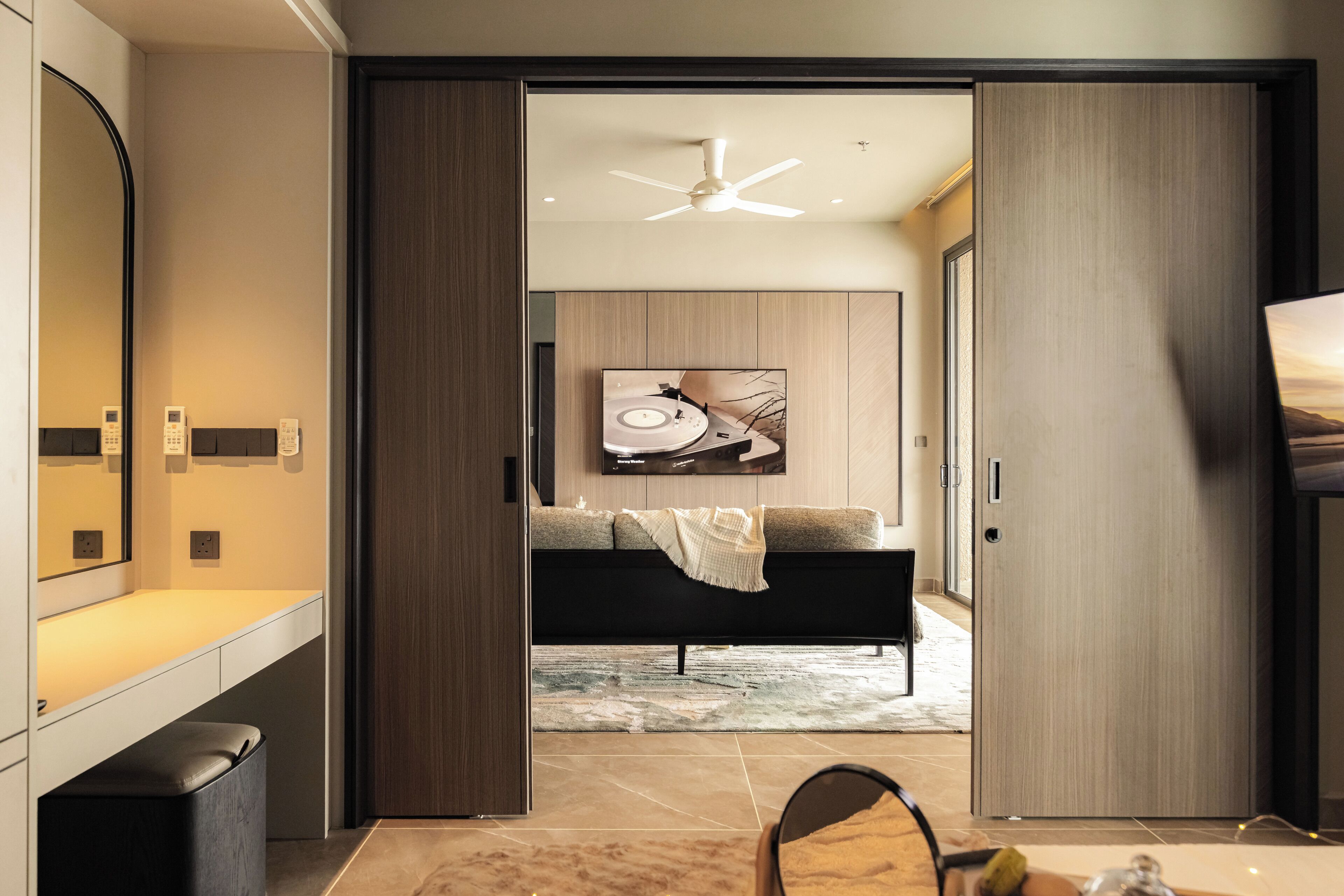 A modern bedroom with a bed, a TV, and a large mirror.
