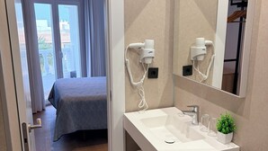 A modern bathroom with a white sink, mirror, and towel rack. - Hostal Juan Carlos (Carboneras)
