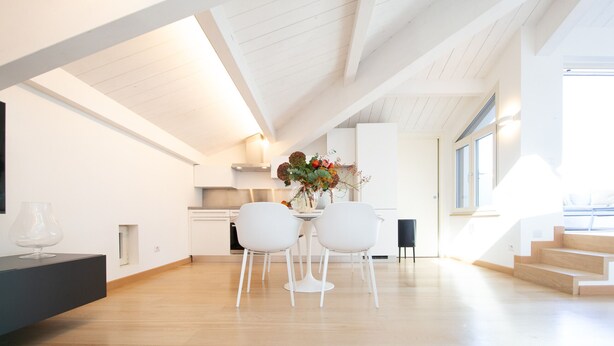 A modern kitchen with white cabinetry, a dining area with a white table and chairs, and a staircase leading to an upper level. - Loft Elisa, with terrace and car place (Lucca)