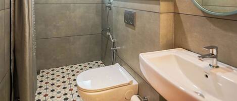 Baño con inodoro, lavamanos, ducha y ventana.