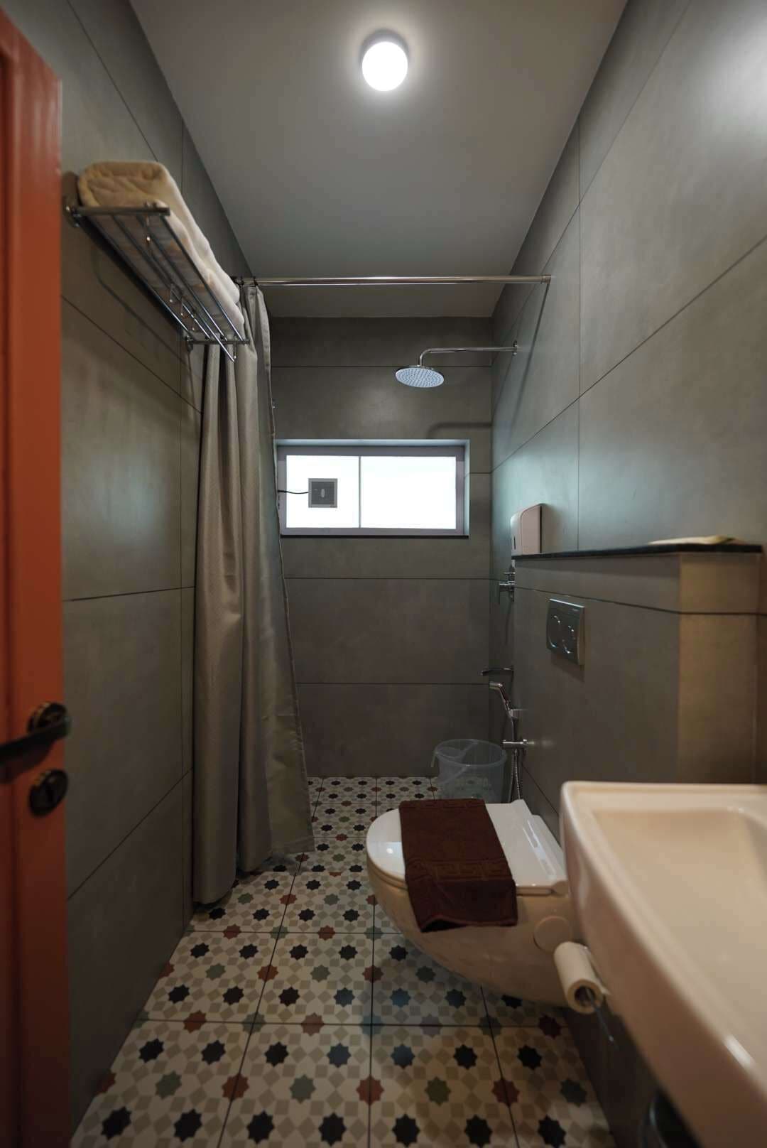 Een kleine badkamer met douche, toilet en wastafel.