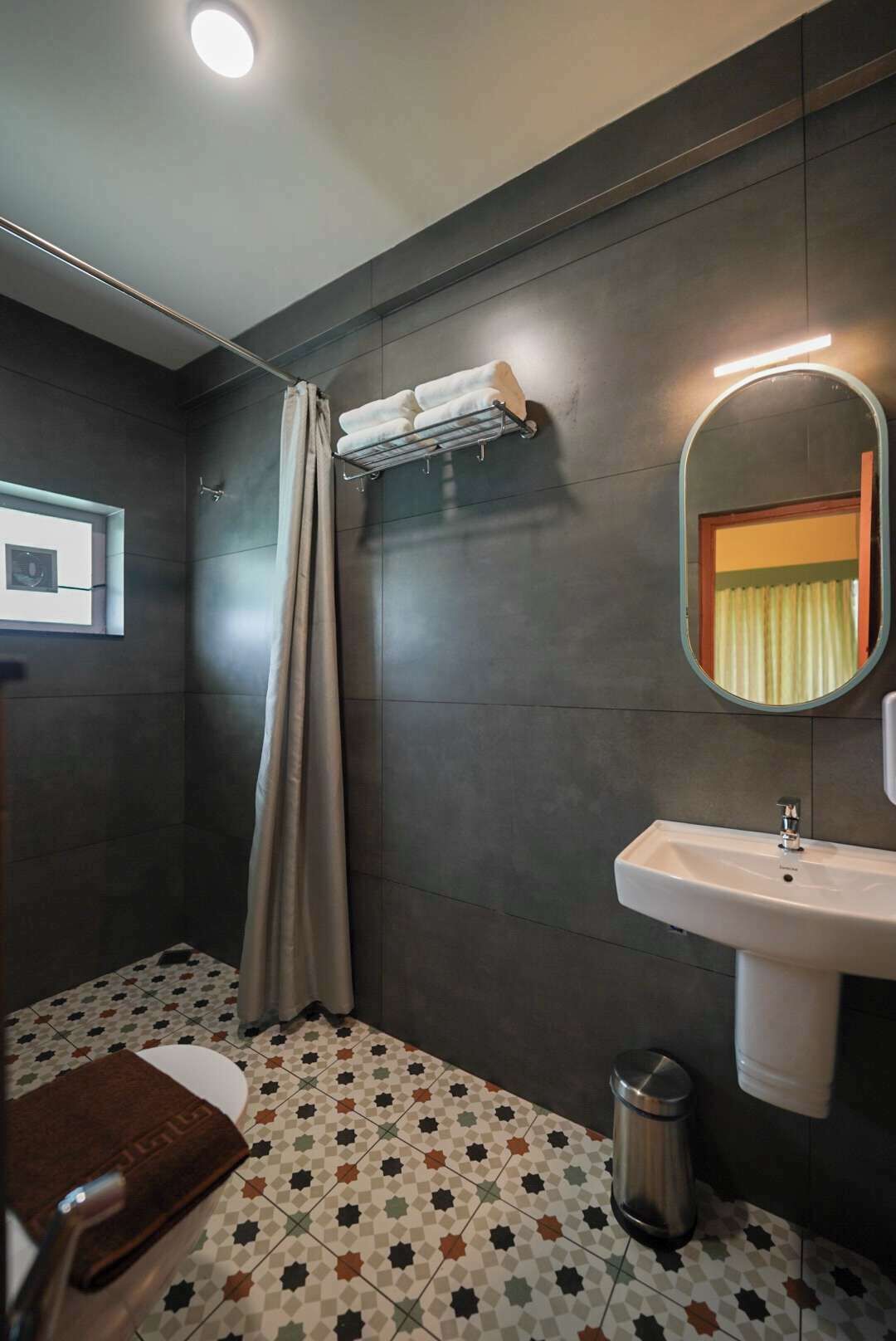 Un bany modern amb dutxa, un lavabo i un vàter.