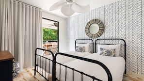 A bedroom with a bed, a ceiling fan, a window with curtains, and a patterned wall. - The Anchorage - by Lifestyle. Brunswick Heads (NEW BRIGHTON)