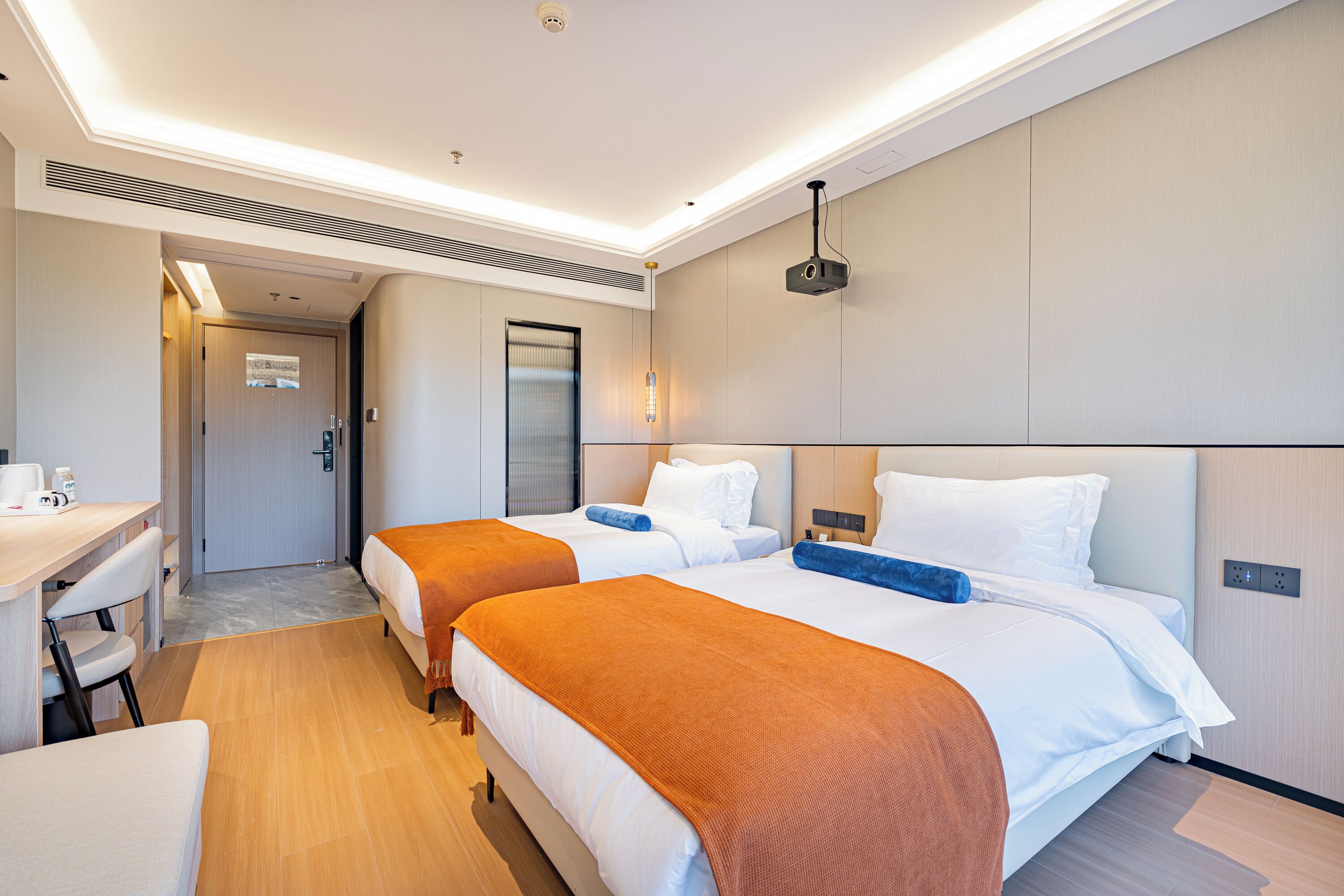 Ein Hotelzimmer mit zwei Betten, einem Schreibtisch und einem Badezimmer.
