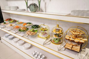 A buffet with various food items and utensils. - ELC Luxury Hotel Danang - An Thuong Walkin Street (Da Nang)