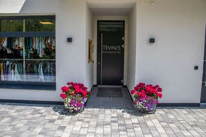 A storefront with a sign reading "TEVIN'S BOUTIQUE SUITES" and a window displaying clothing.