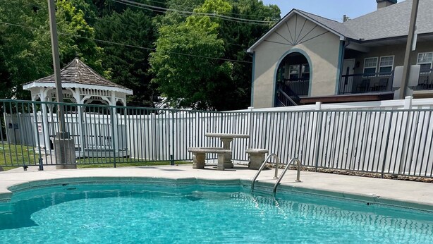 A swimming pool with a basketball hoop and a beach ball.