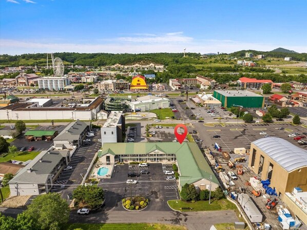An industrial area with warehouses, a parking lot, and a large building with a green roof.