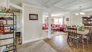 A spacious living area with a red sofa, a dining table with chairs, and a bookshelf. - Quiet Family Home in Headland w/ Games & Yard (Headland)