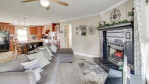 A living room with a gray sectional sofa, a fireplace, and a ceiling fan. - Quiet Family Home in Headland w/ Games & Yard (Headland)