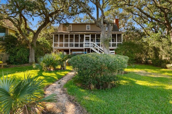 A two-story house with a covered porch and a staircase leading to the upper floor.