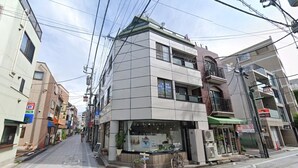 Un edificio moderno con escaparate en la planta baja, que incluye un amplio escaparate y una bicicleta estacionada afuera.