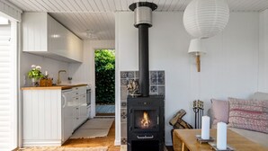 Una cocina moderna con armarios blancos, una encimera de madera y una estufa empotrada.